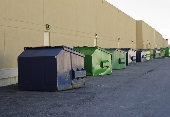 a crowd of dumpsters of all colors and sizes at a construction site in Prairie View TX